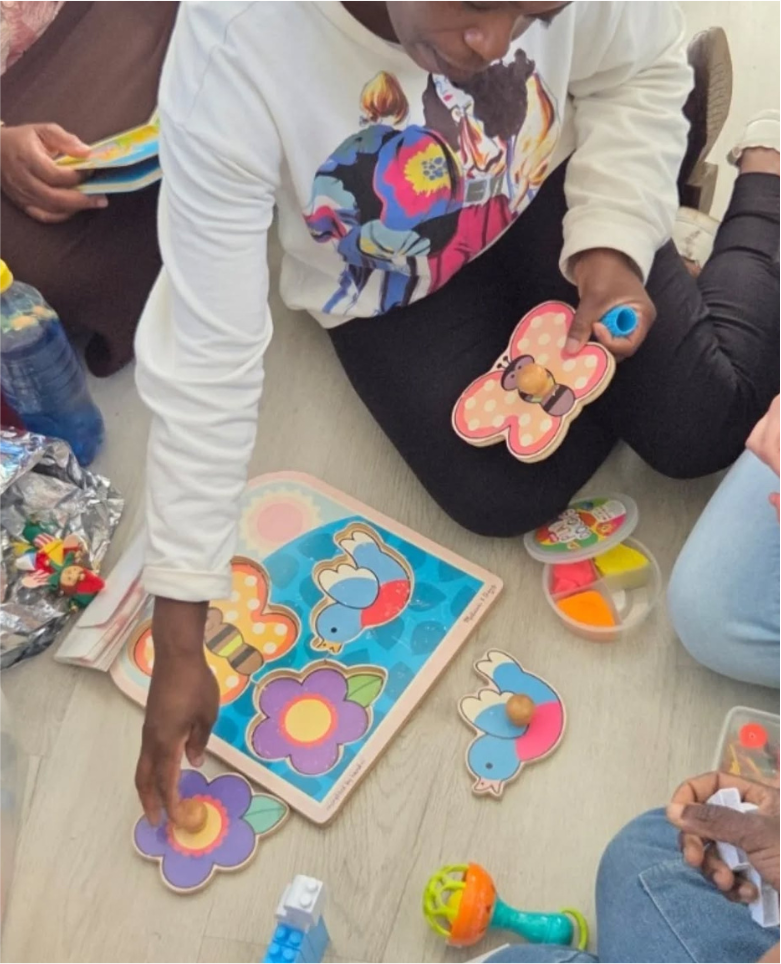 A nanny guiding children through a hands-on puzzle activity