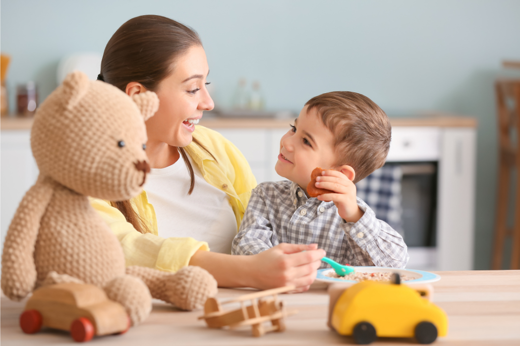 A laughing baby with a smiling caregiver