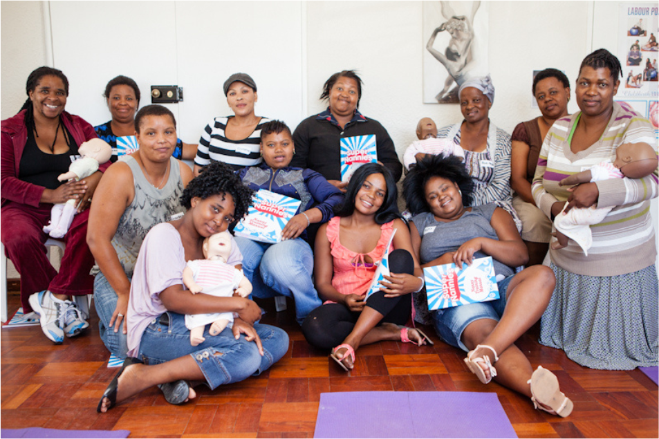 A group of nannies completing their training together with practice dolls