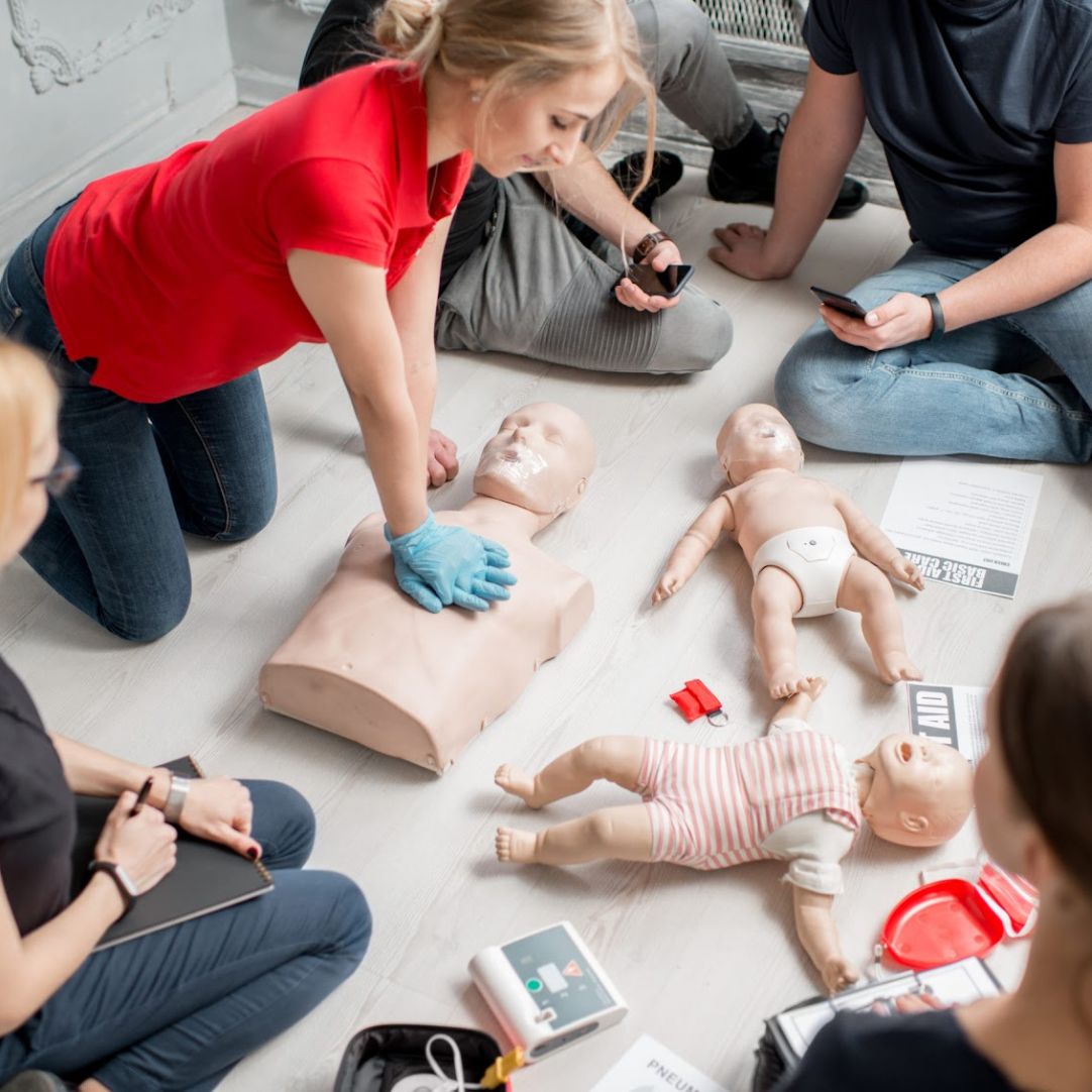 A Super Nannies trainer demonstrating infant first aid on a baby manikin
